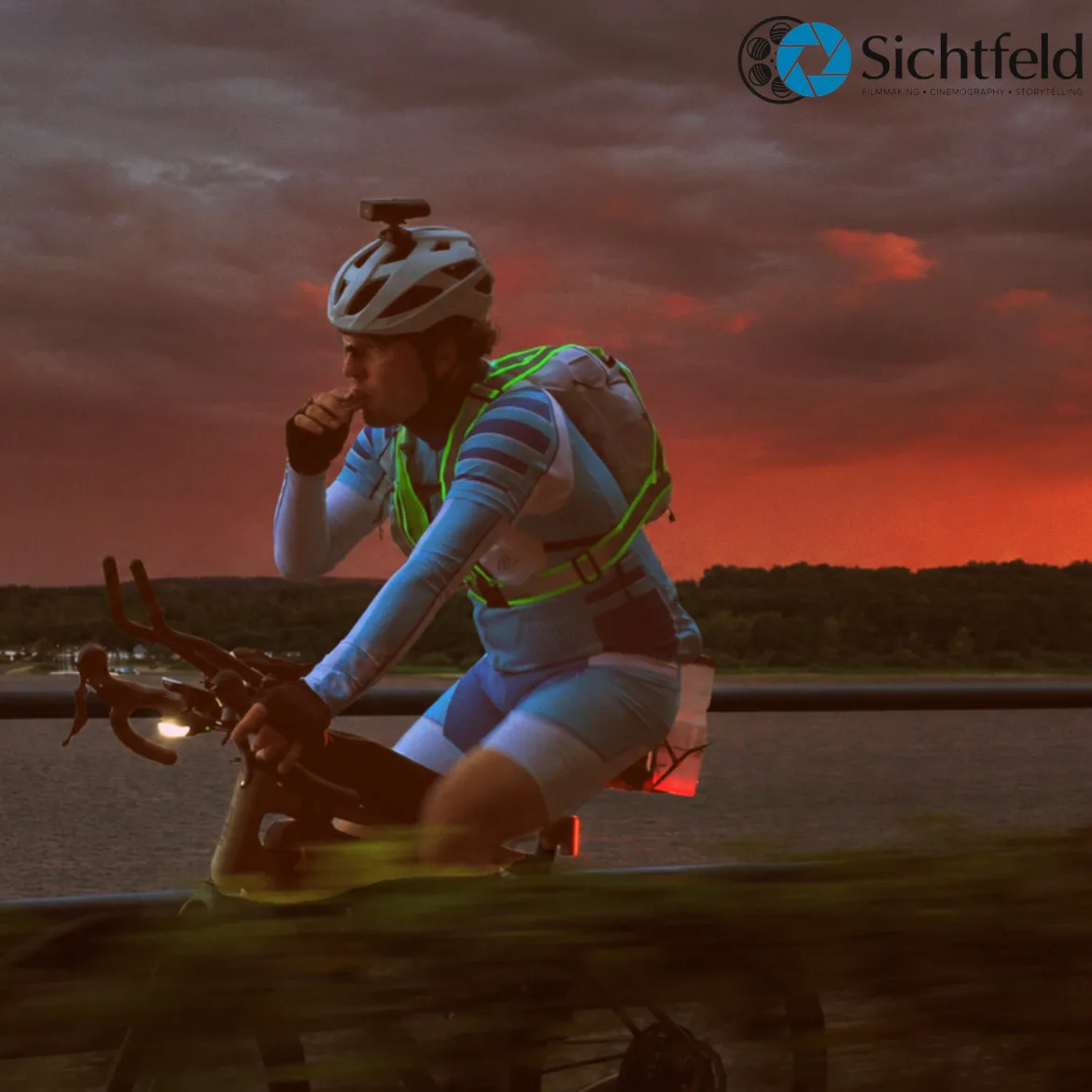 Silas auf dem Rad am Wasser unter einem dunklen Abendhimmel