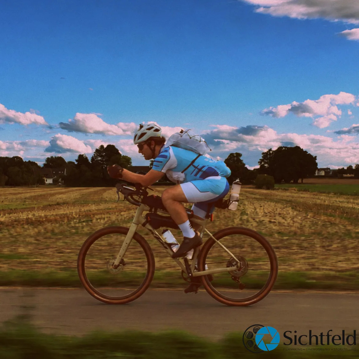 Silas fährt auf seinem Rad an Feldern vorbei