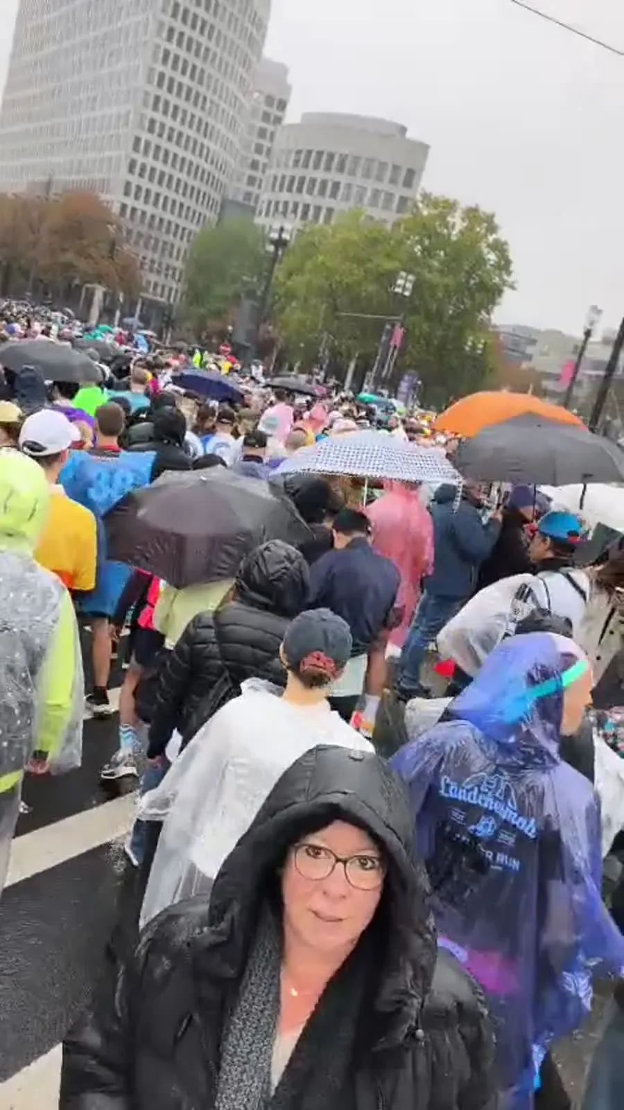 Viele Menschen mit Regenschirmen und Regenponchos draußen beim Frankfurt-Marathon